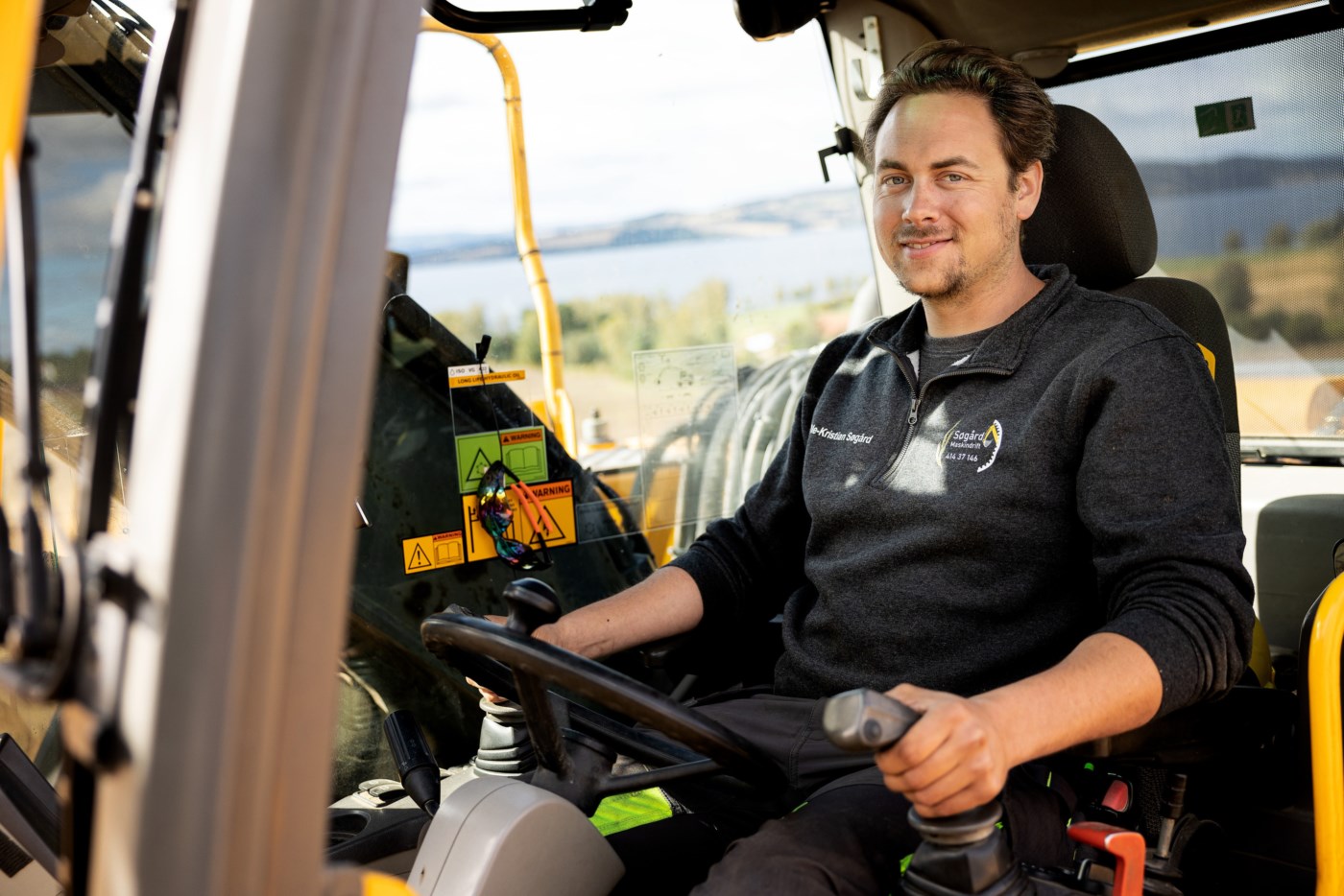 Mann kjører traktor